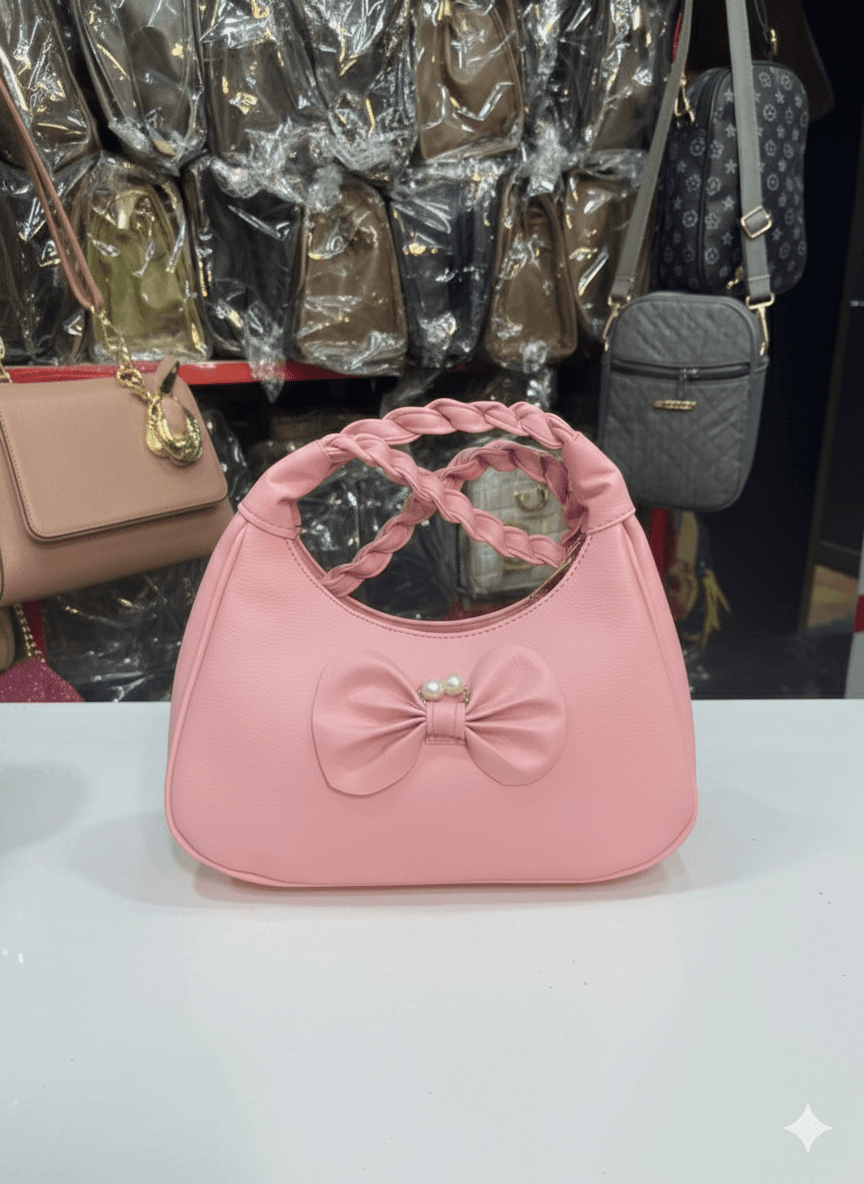 pink shoulder bag with a braided top handle and a decorative bow
