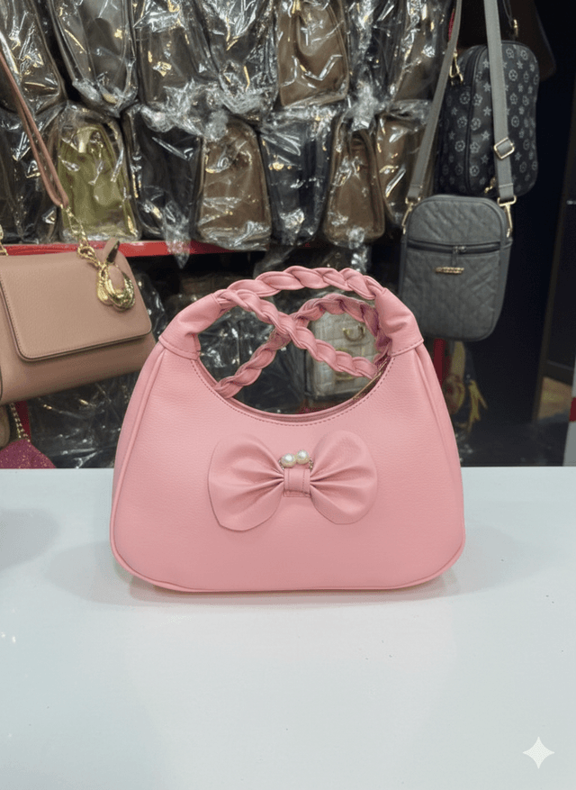 pink shoulder bag with a braided top handle and a decorative bow